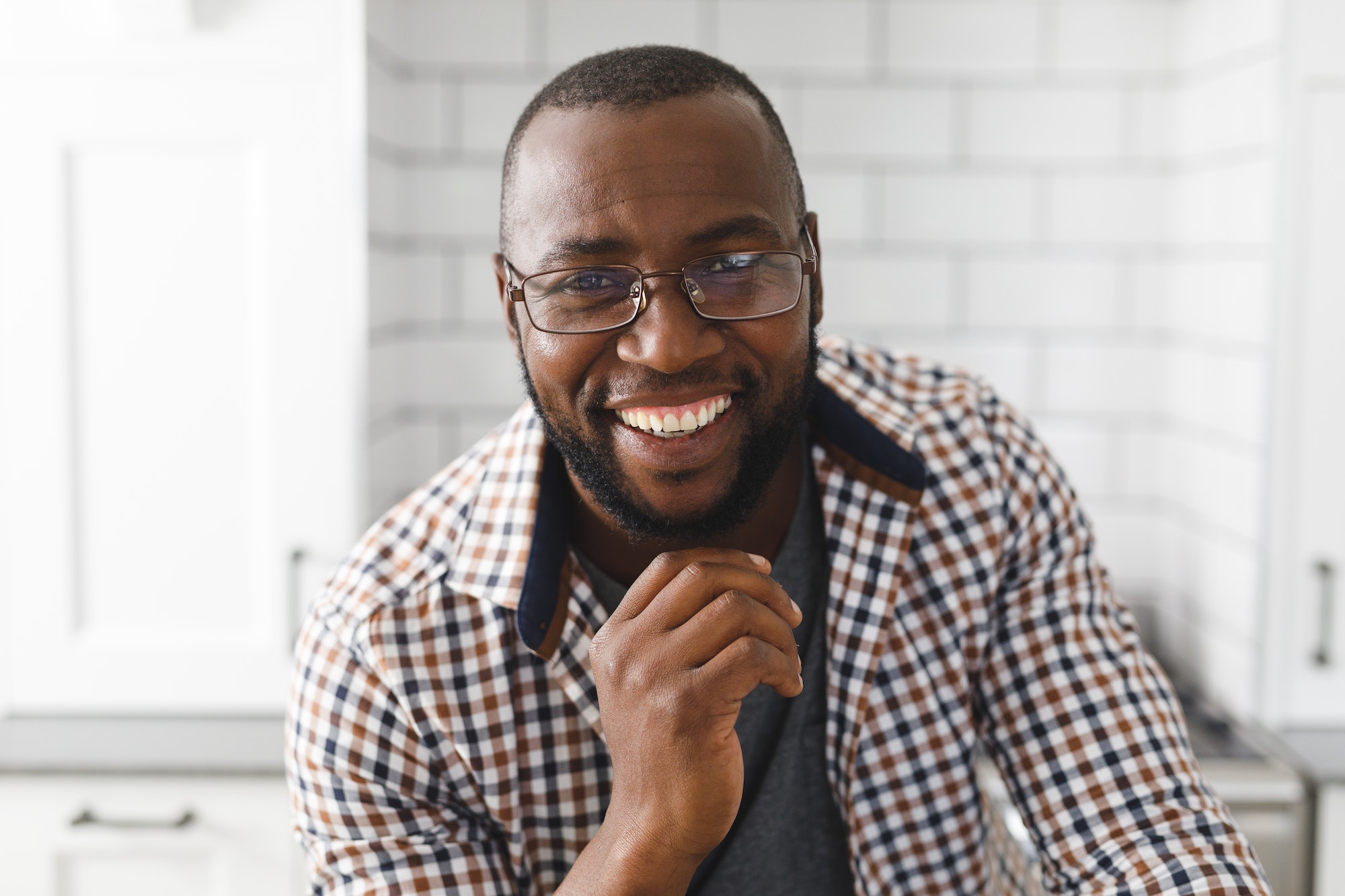 Portrait of happy african american man in kitchen, looking to camera and smiling