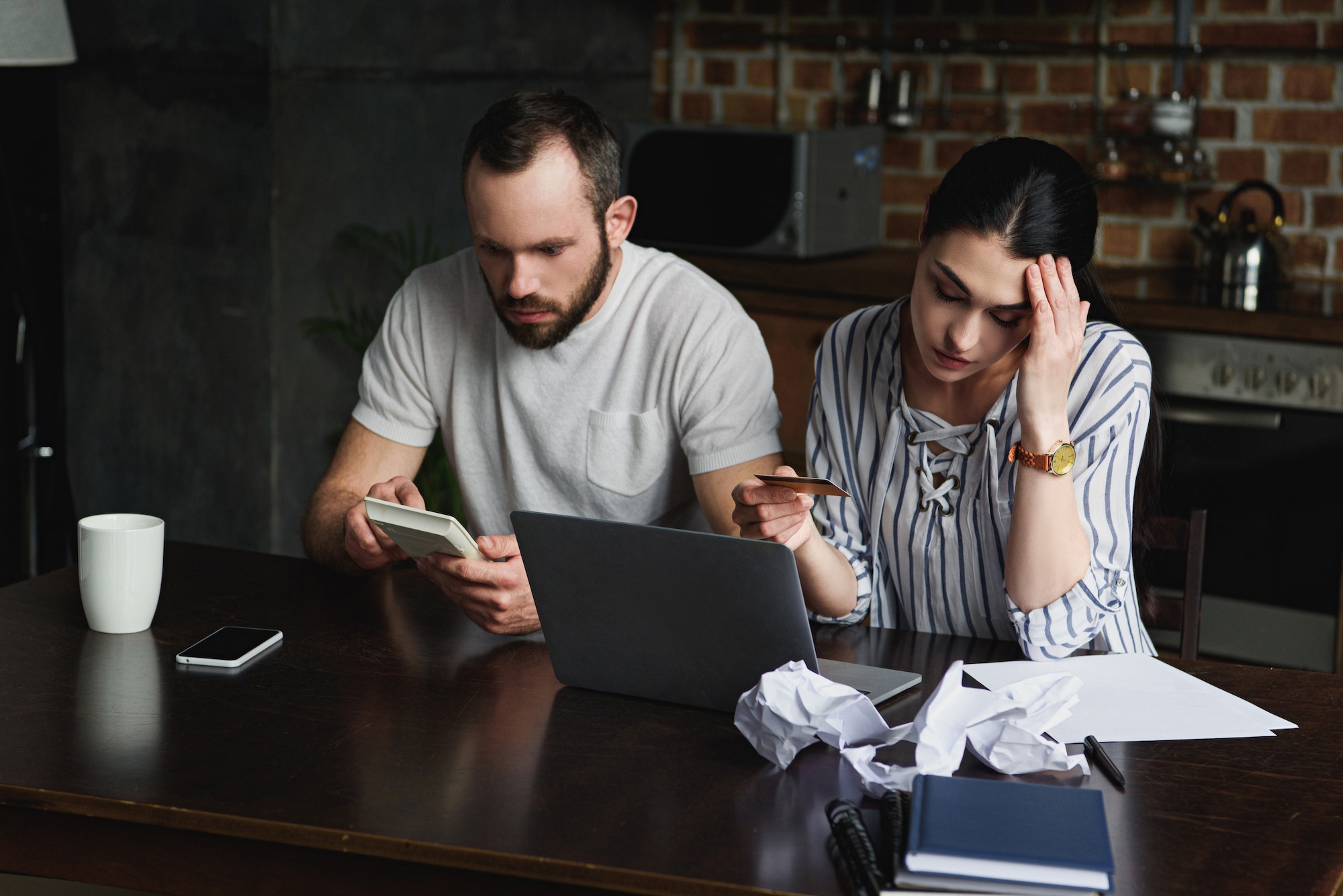 stressed young couple counting tax and bills with laptop and calculator
